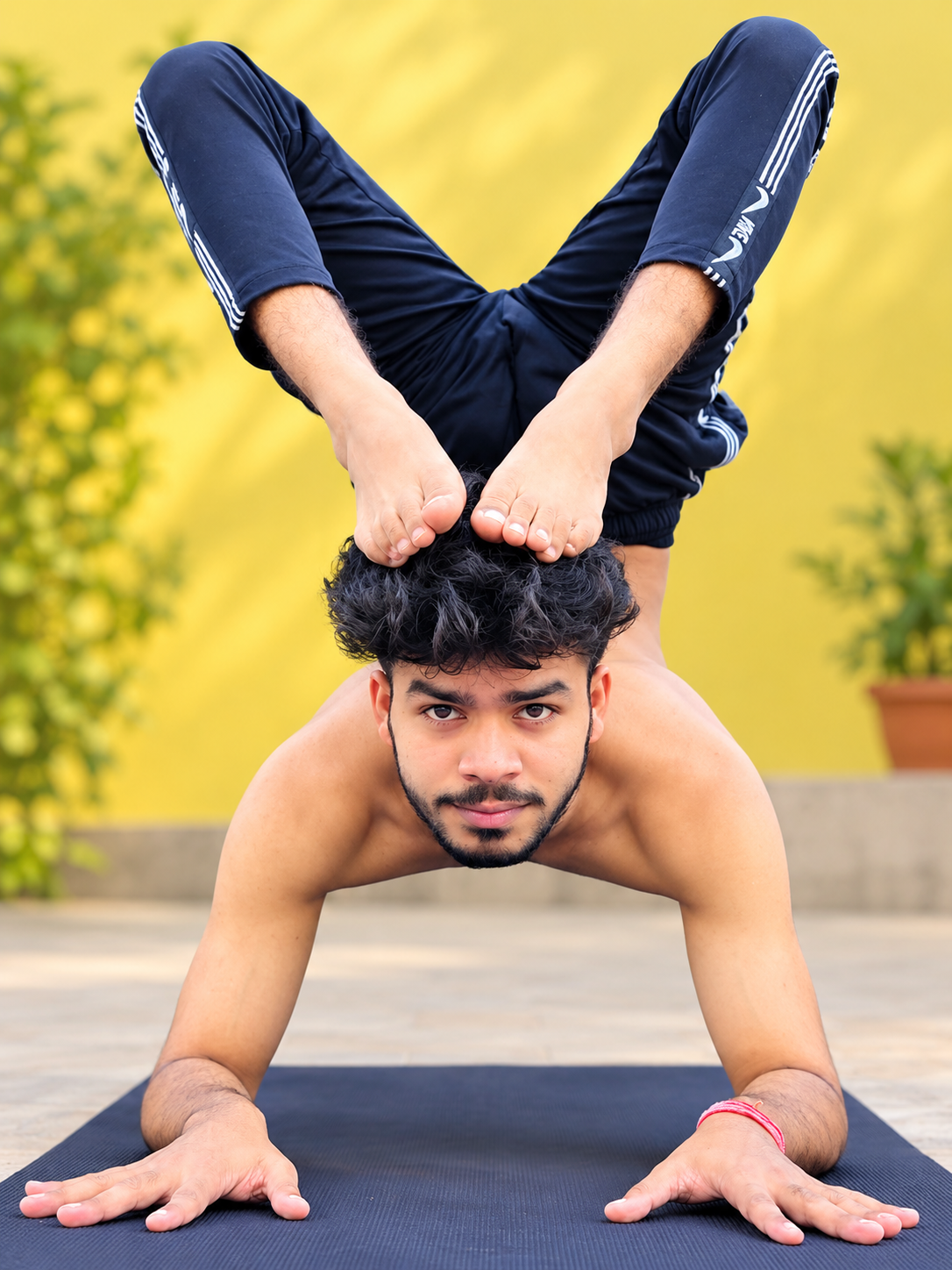 Experienced practitioner practising Advance Yoga at home with a certified yoga trainer